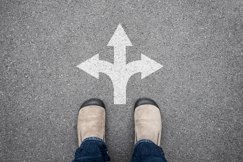 standing infront of an arrow with different directions